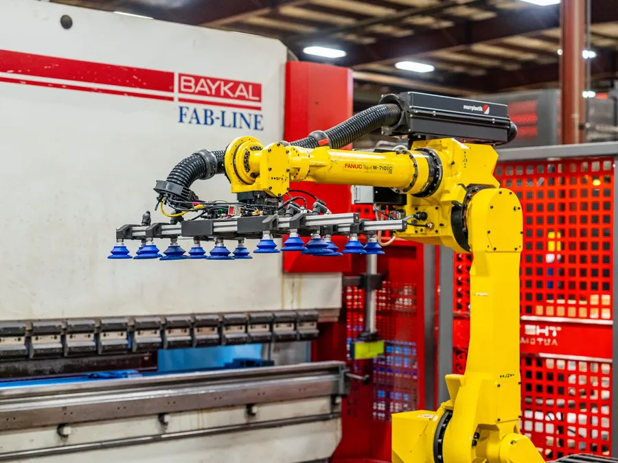 Close view of the vacuum-cup gripper on the robot wrist, the Baykal brake behind it