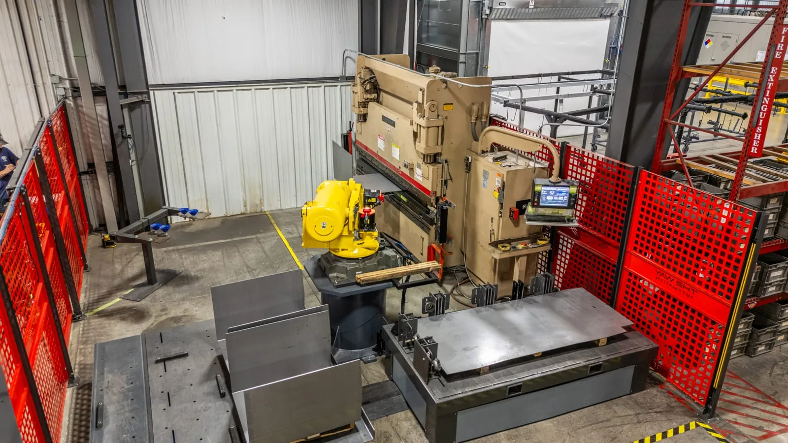 The FANUC R-2000iB/200R inside the fenced Thunder Creek cell, tending the Cincinnati press brake with sheet-metal blanks staged beside it